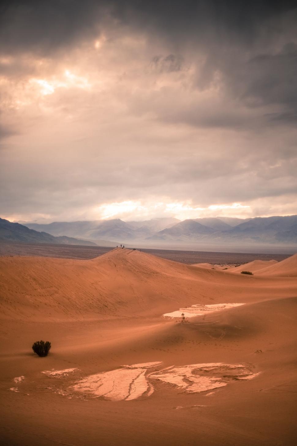 Free Image of Moody desert landscape with stormy sky and vast dunes 