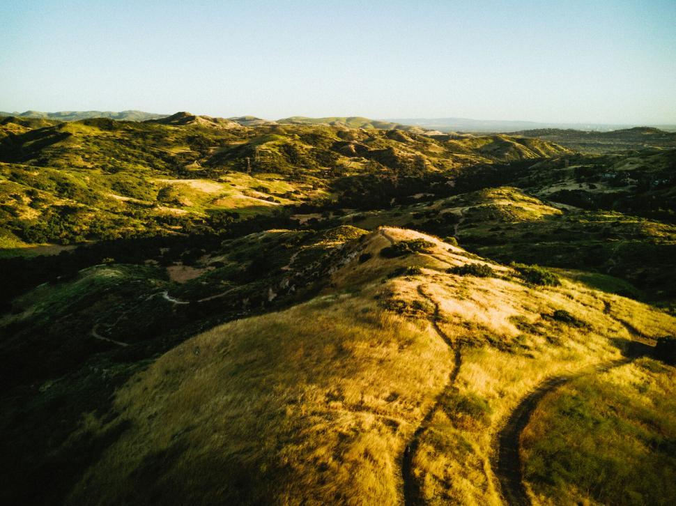 Free Image of Golden sunlight over rolling hills 