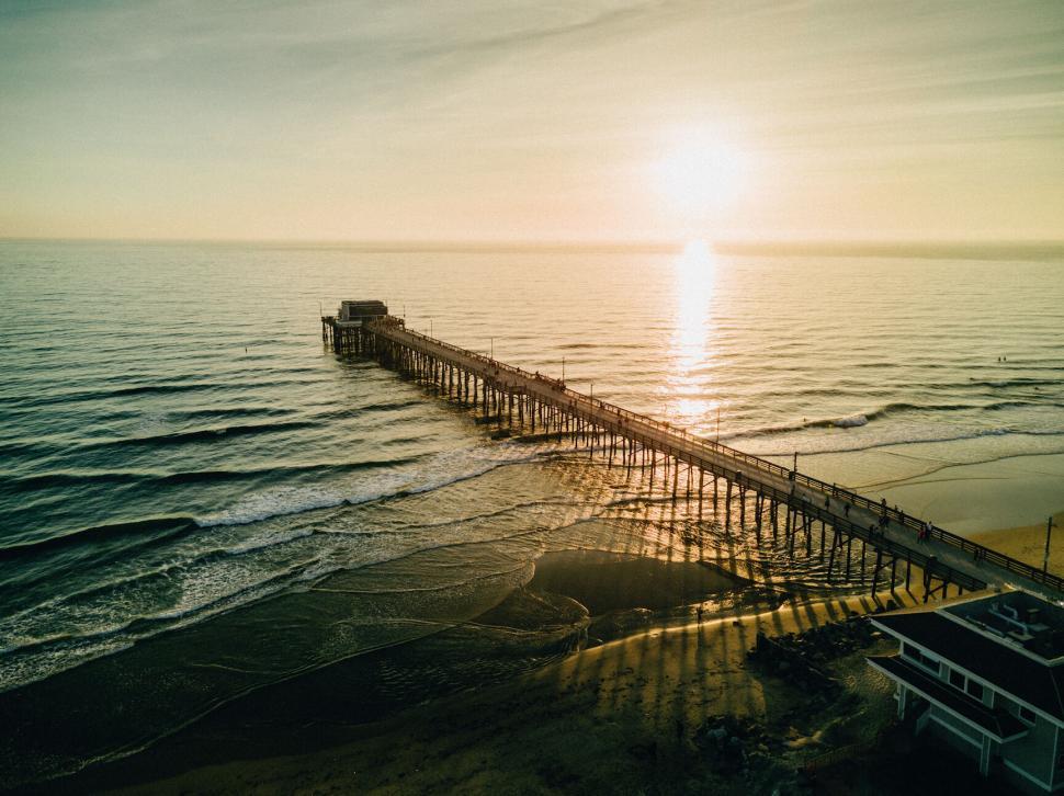 Free Image of Pier extending into ocean at sunset 