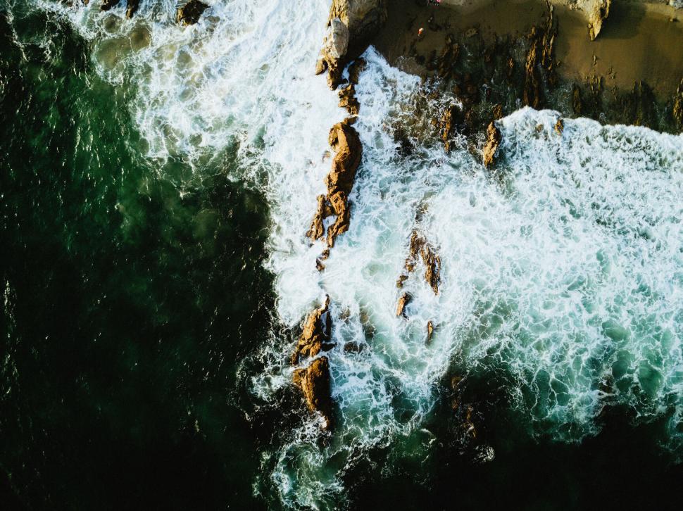 Free Image of Ocean waves crashing against rocky shore 