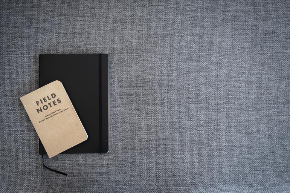 Free Image of Flat lay of notebook on grey fabric 