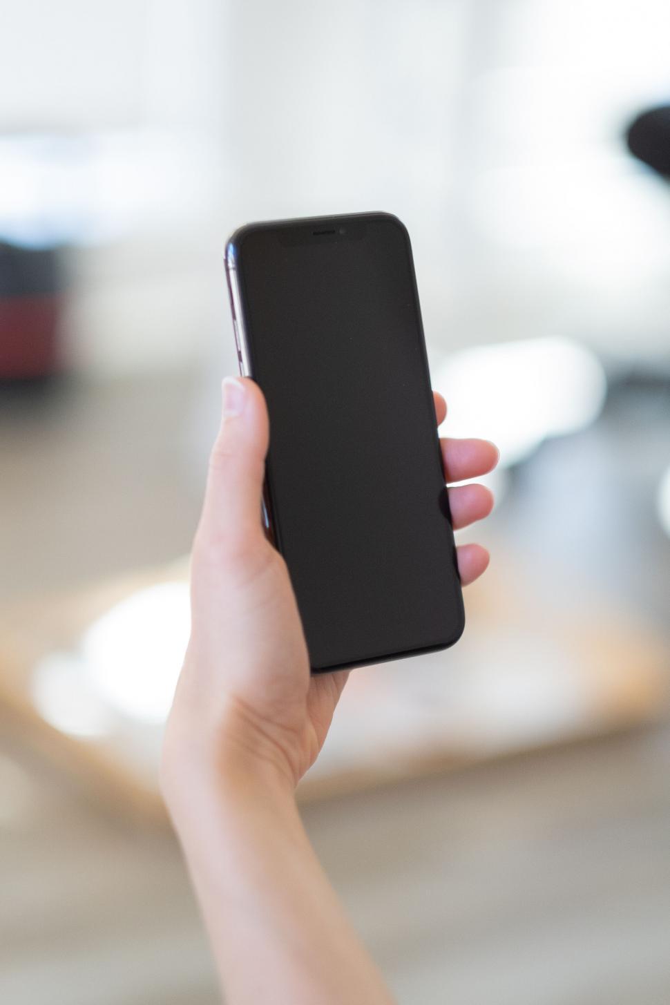 Free Image of Hand holding a smartphone with black case 