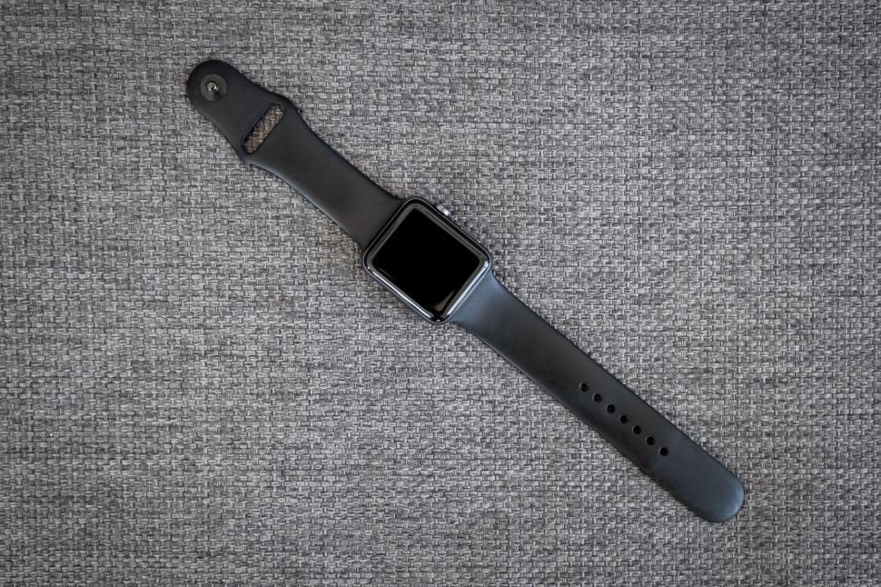Free Image of Smartwatch with black strap on grey fabric 