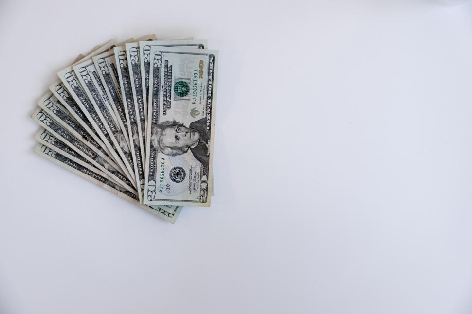 Free Image of Fan of dollar bills on white surface 