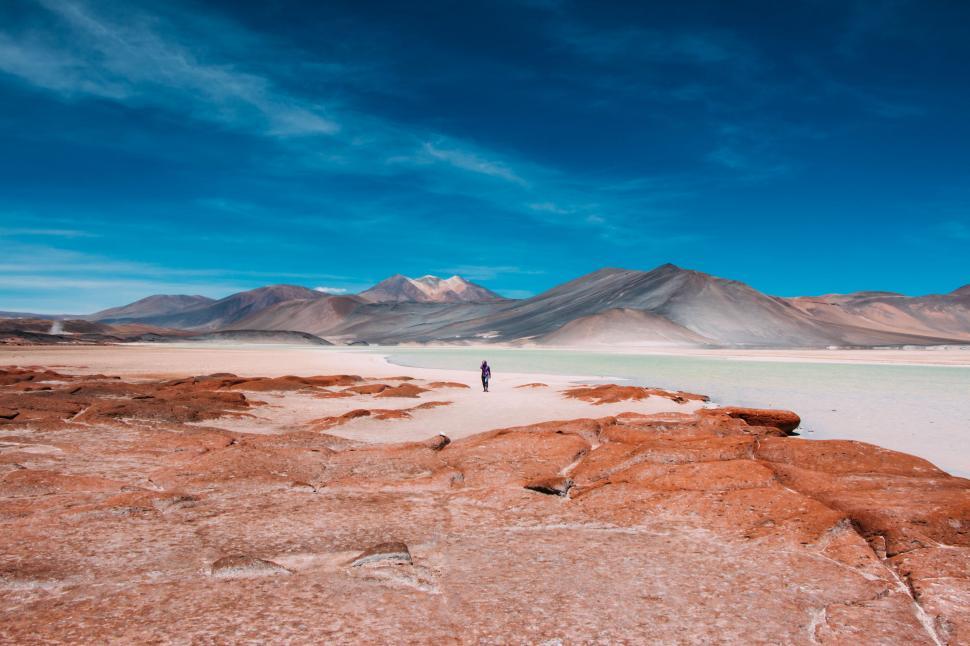 Free Image of Stunning salt flats with distant travelers and sky 