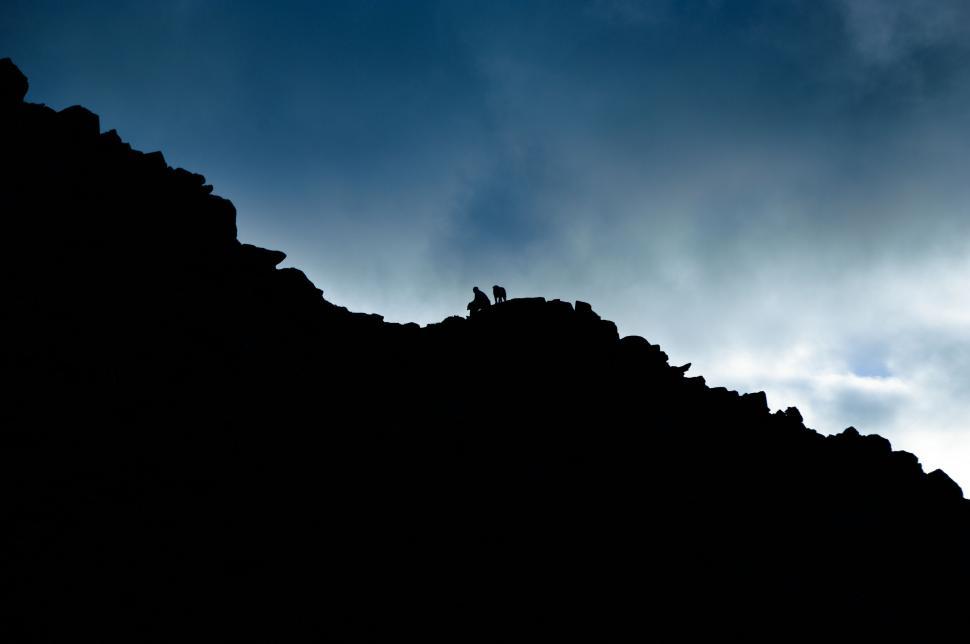 Free Image of Silhouetted figures on a mountain ridge 