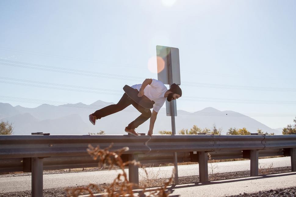 Free Image of Man casually leaning against a highway sign 