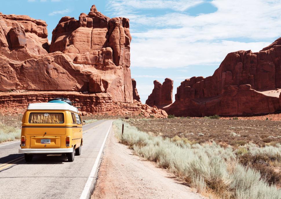 Free Image of Yellow van driving through desert canyons 