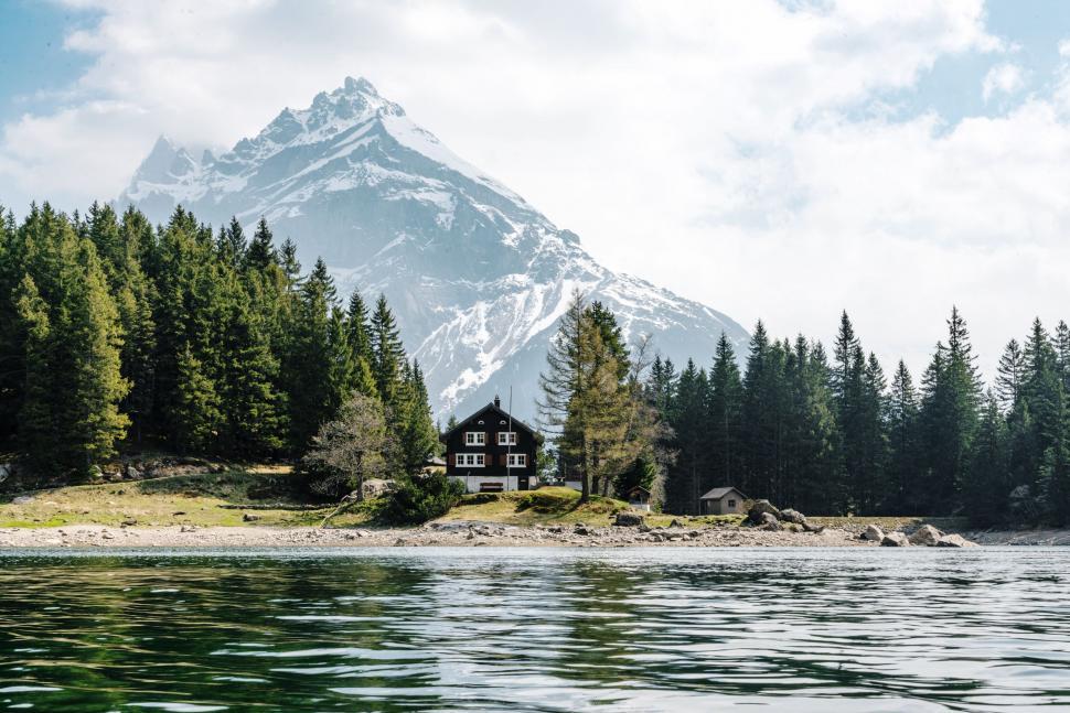 Free Image of House on lakeshore with mountain backdrop 