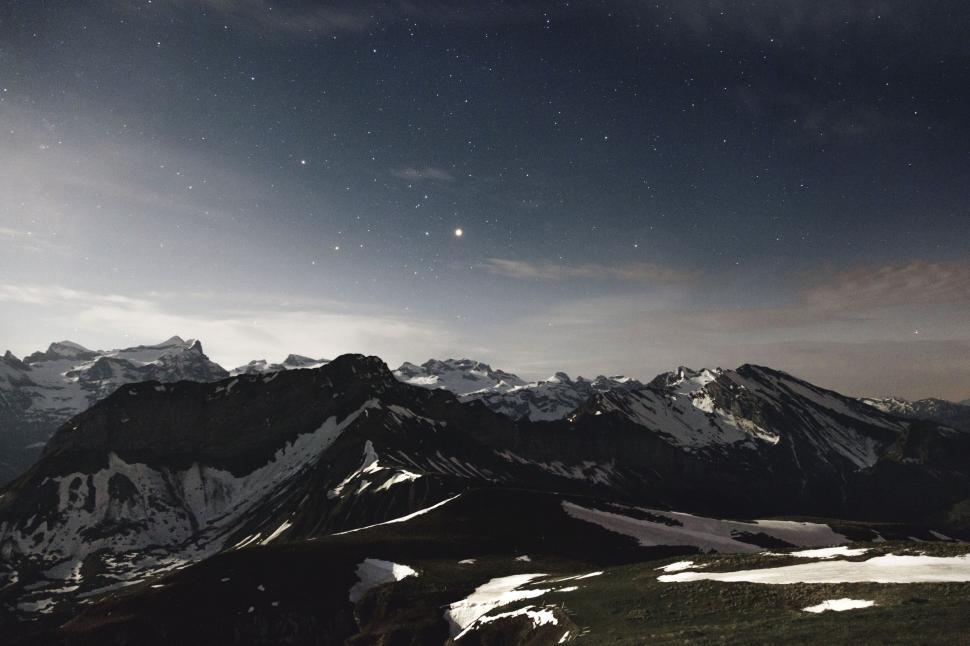 Free Image of Starry night sky over snowy mountains 