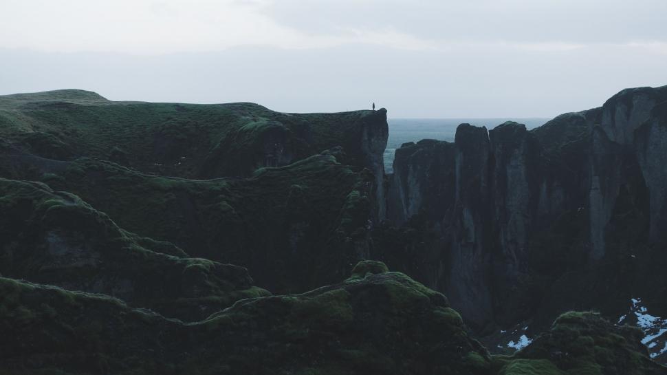 Free Image of Majestic green canyon landscape with a lone figure 