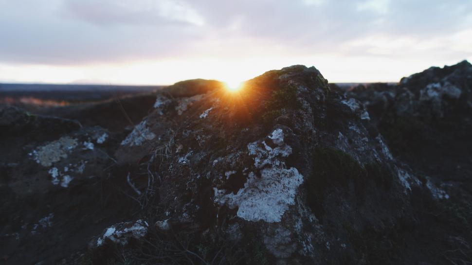 Free Image of Sunrise over rocky landscape with warm glow 