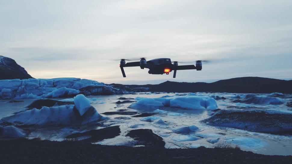 Free Image of Drone hovering over icy blue glacial waters 
