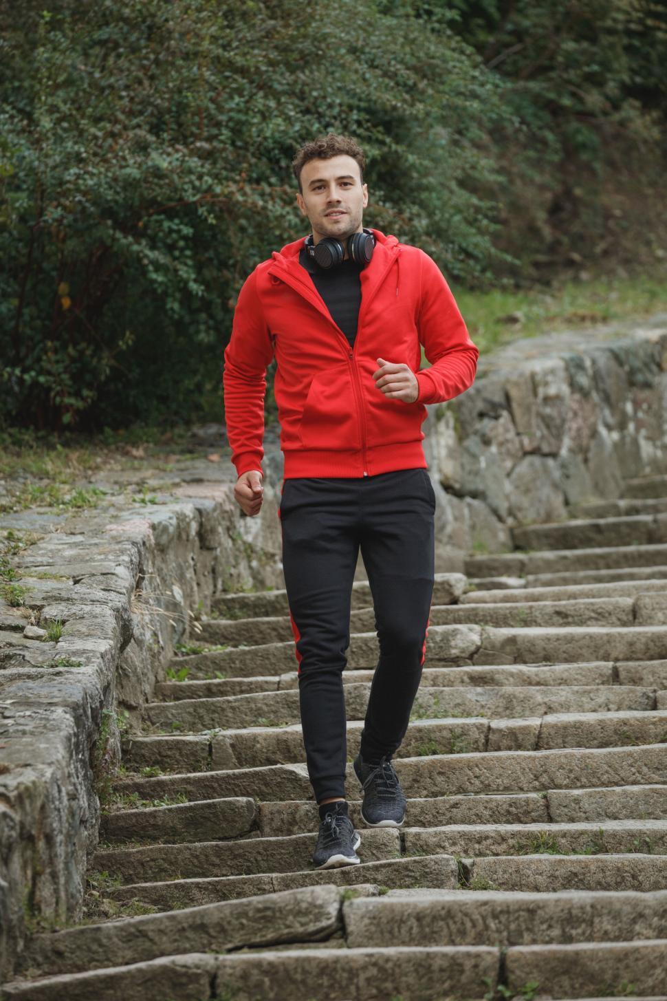Free Image of Man jogging on stone steps outdoors 