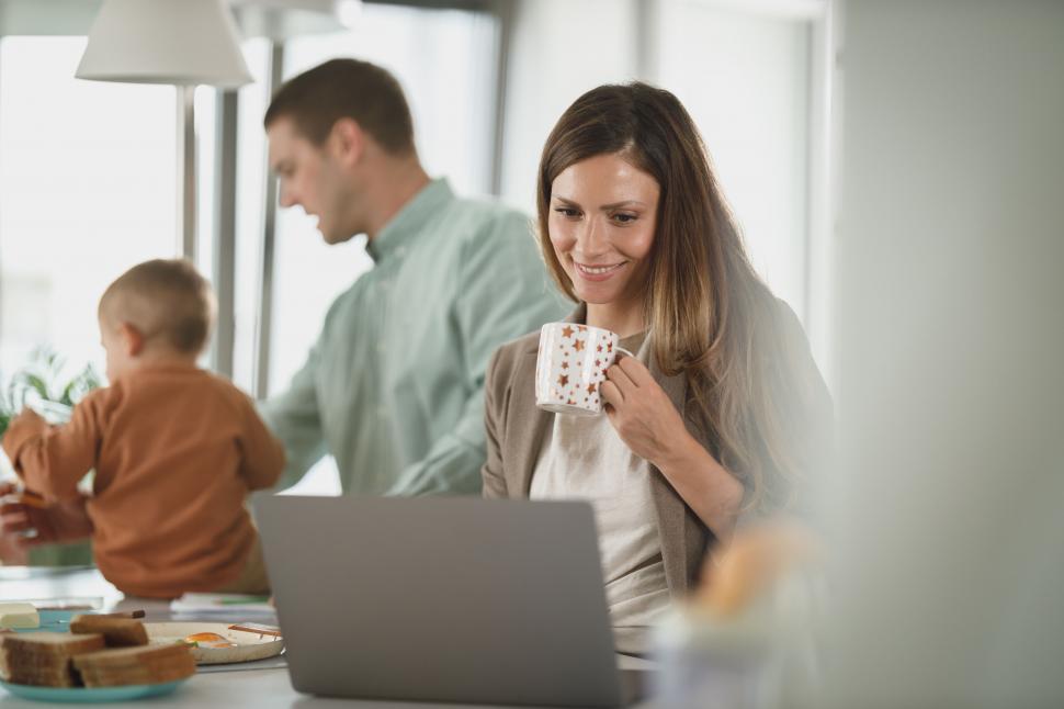 Free Image of Woman working remotely with family in background 