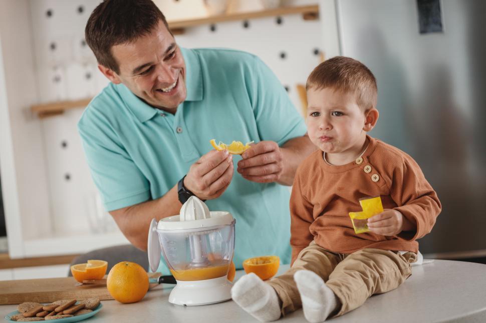 Free Image of Father and son making orange juice 