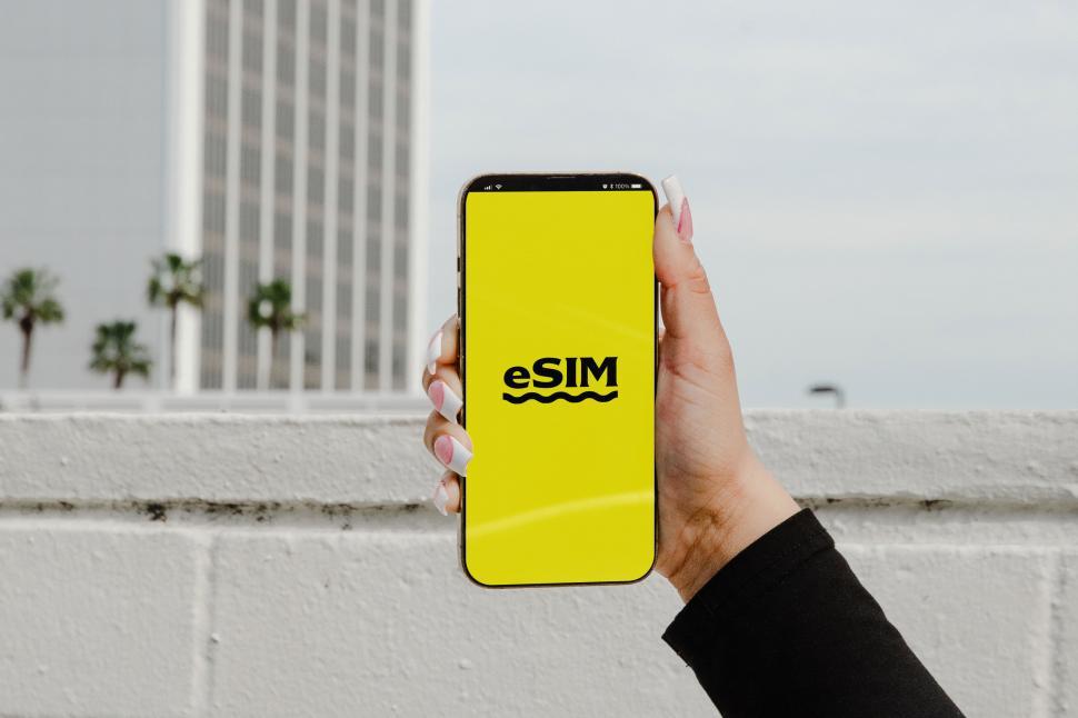 Free Image of A photo displaying a U.S. passport and a smartphone with an eSIM logo, symbolizing modern travel technology  