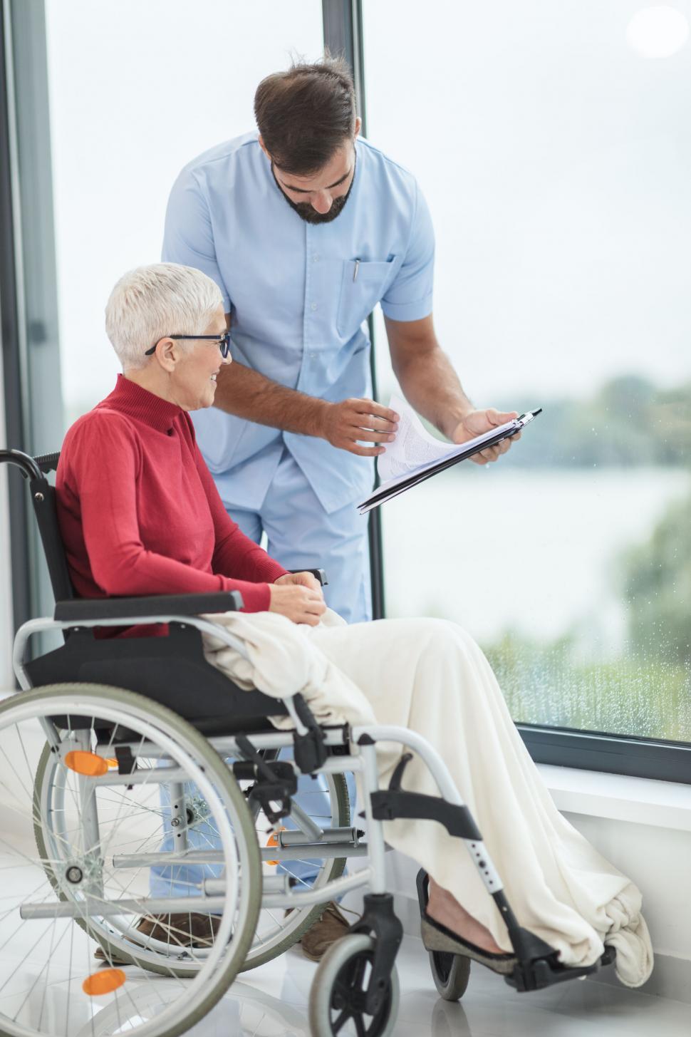 Free Image of Nurse assisting a patient in a wheelchair 