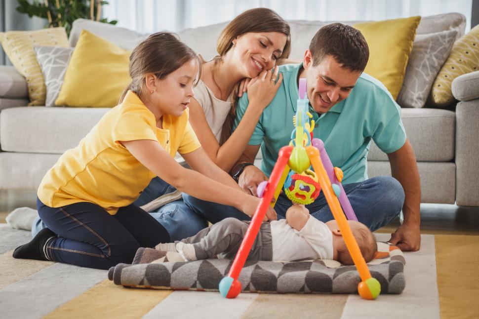 Free Image of Family playing with baby on living room floor 