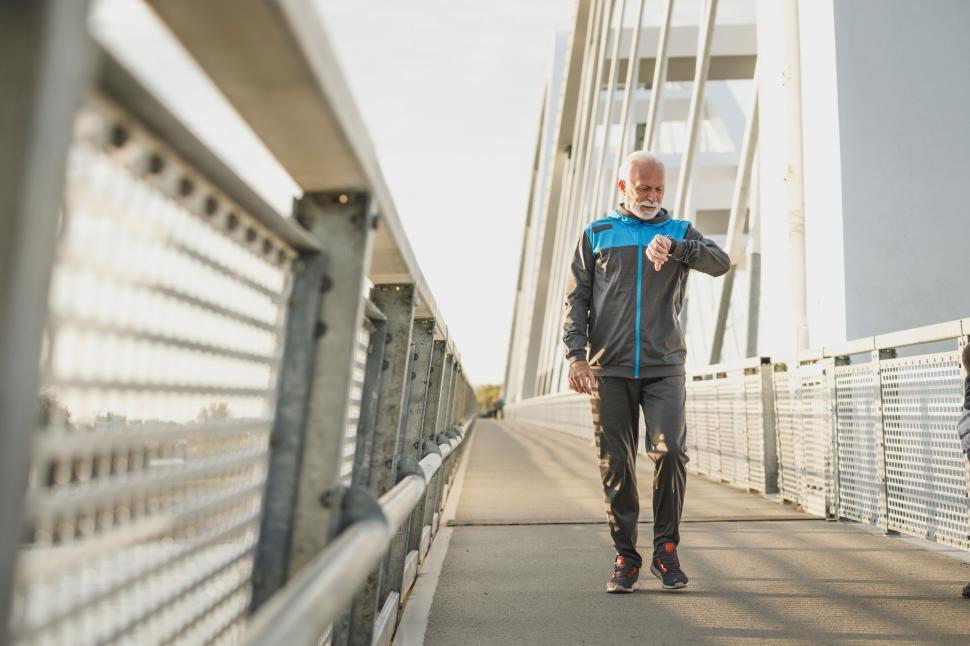 Free Image of Senior man jogging on a bridge 