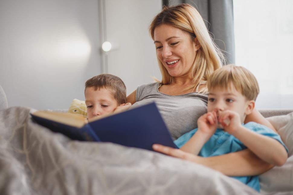 Free Image of Mother reading to children in bed 