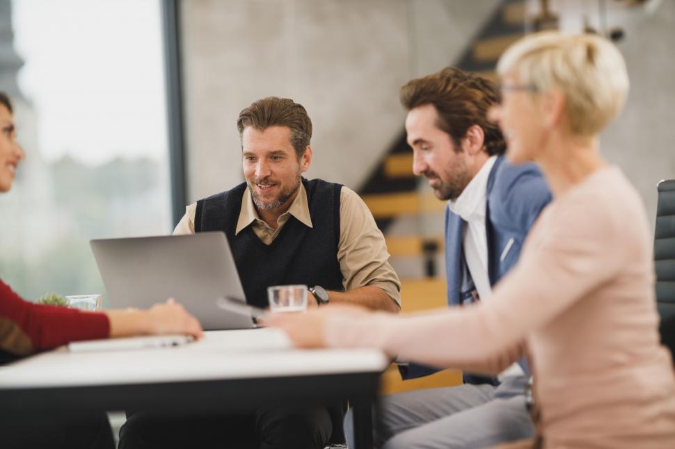 Free Image of Smiling man presenting at a team meeting 