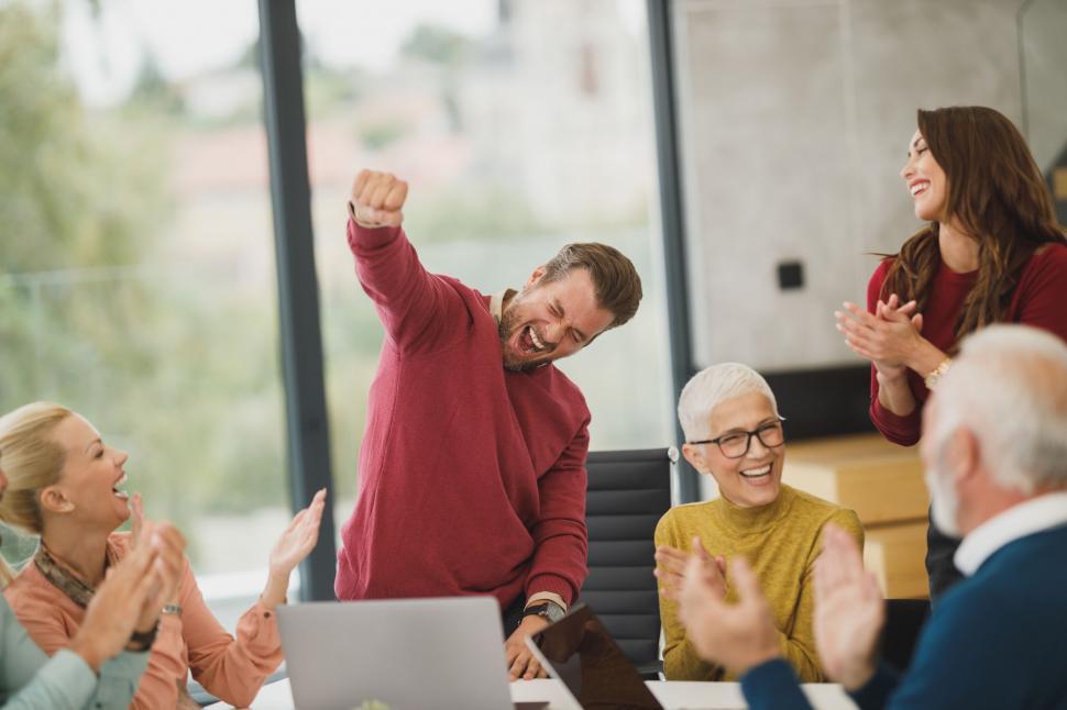 Free Image of Energetic man celebrating with colleagues 