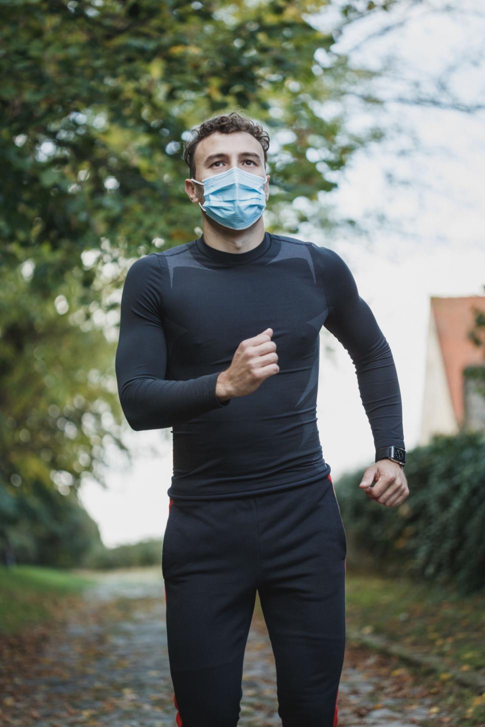 Free Image of Runner wearing a mask on a path 
