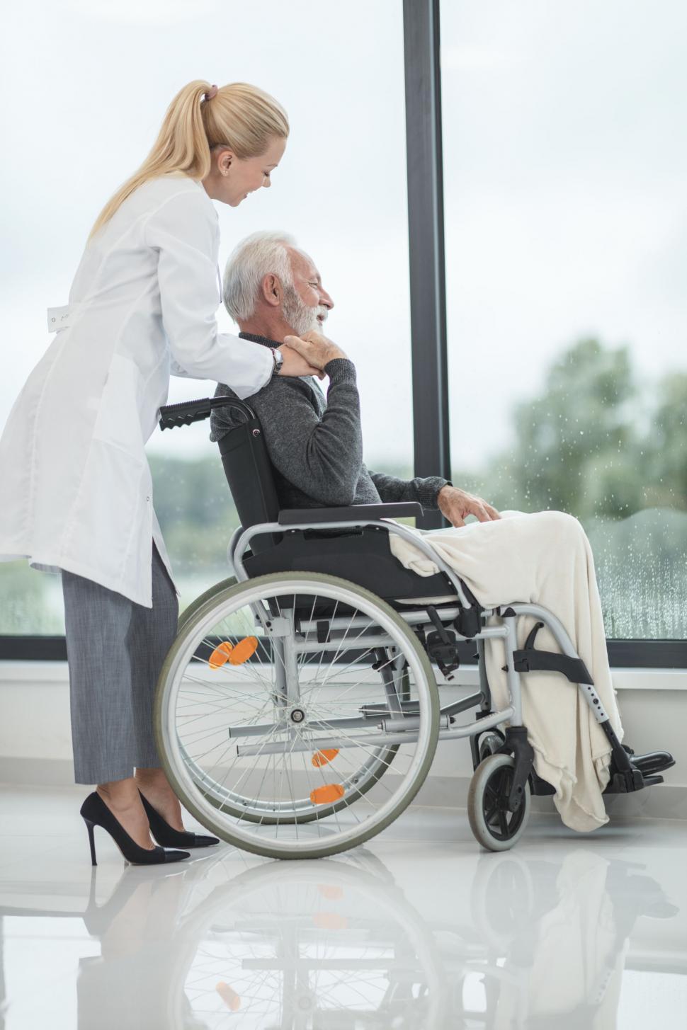 Free Image of Doctor comforting elderly man in wheelchair 