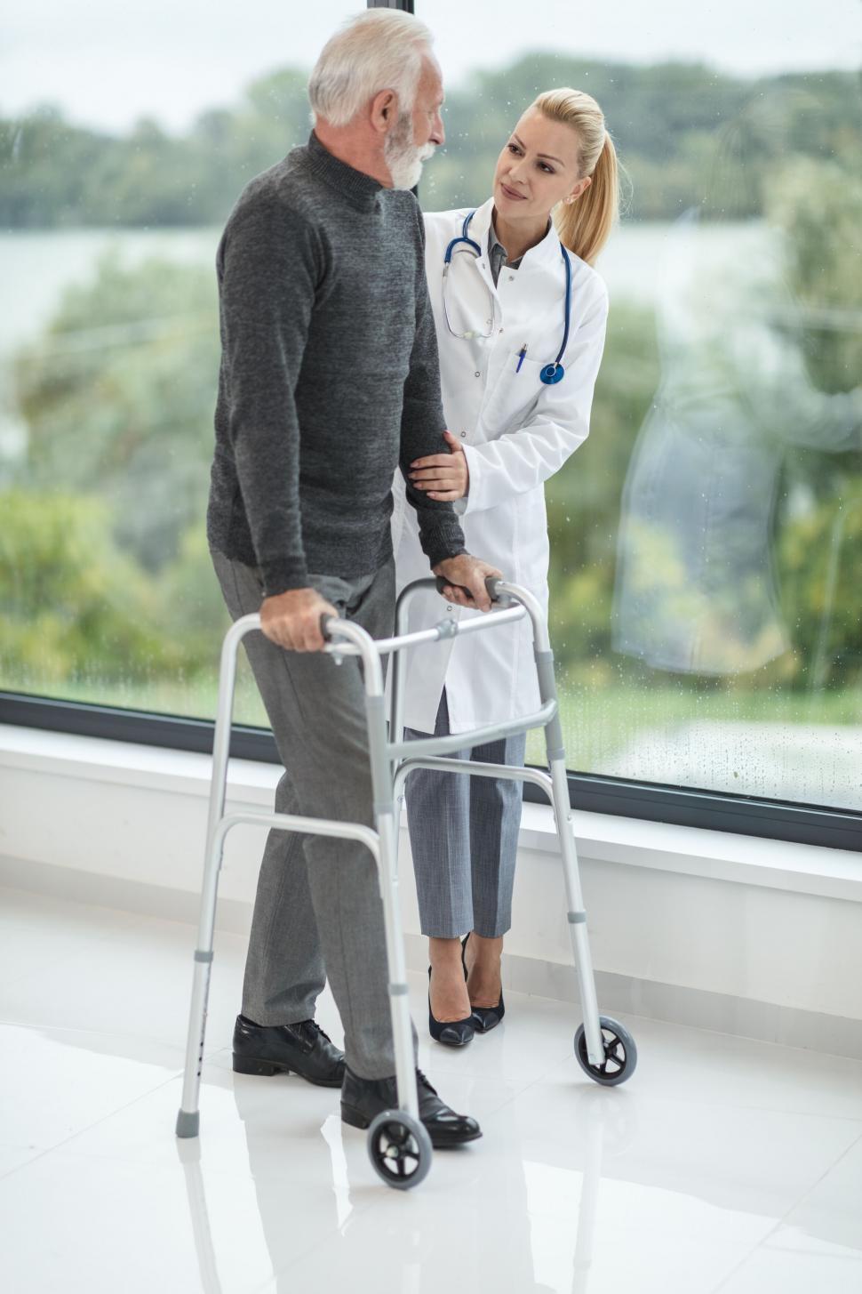 Free Image of Elderly man with walker talking to nurse 