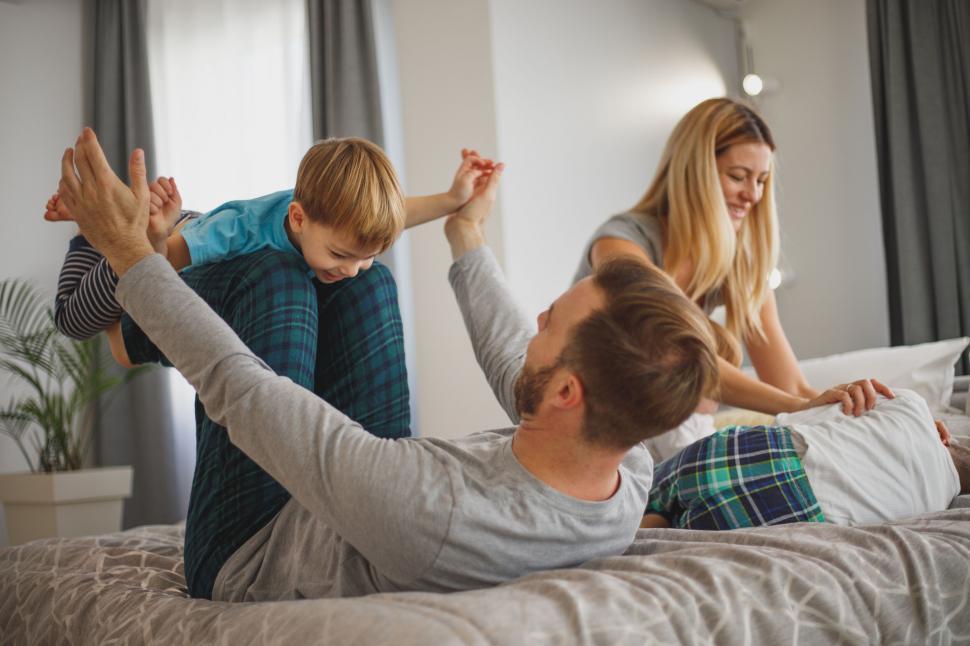Free Image of Family playing together on the bed 