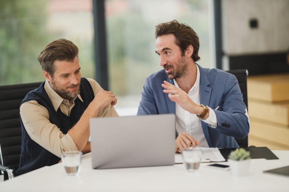 Free Image of Businessmen discussing over laptop in office 