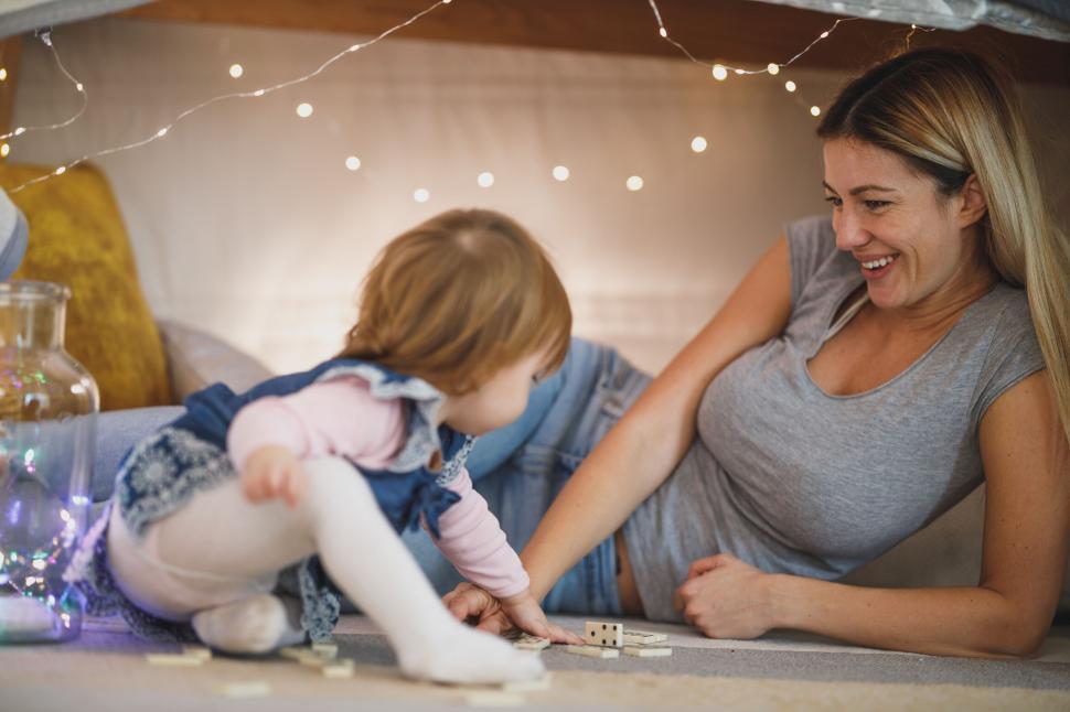 Free Image of Mother and daughter playing under fairy lights 