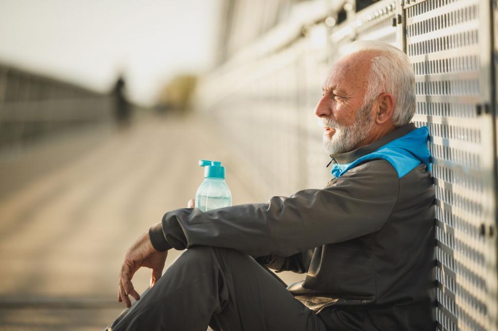 Free Image of Elderly man resting on a bench after a workout 