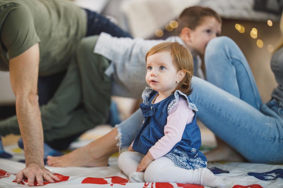 Free Image of Little girl sitting on Twister game mat 
