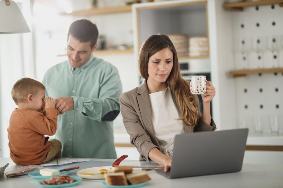 Free Image of Woman working on laptop with family around 