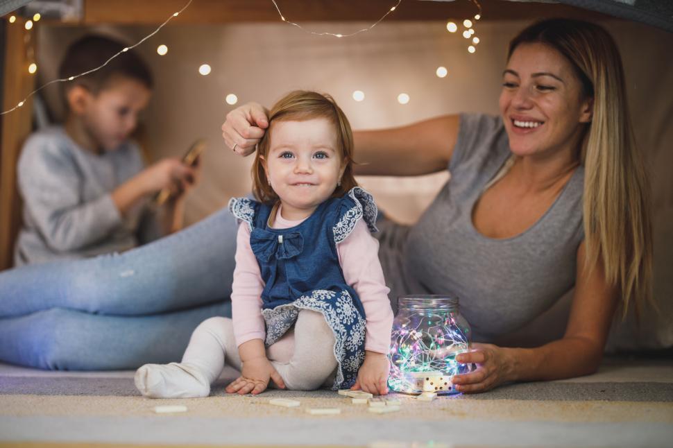 Free Image of Mother and baby playing with fairy lights 
