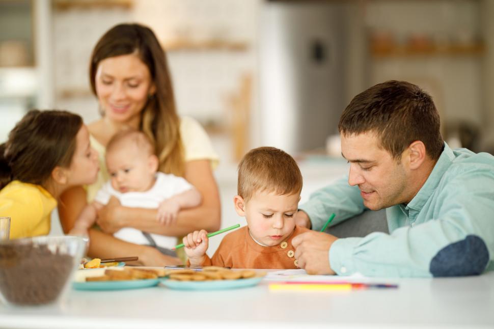 Free Image of Family seated doing creative drawing 