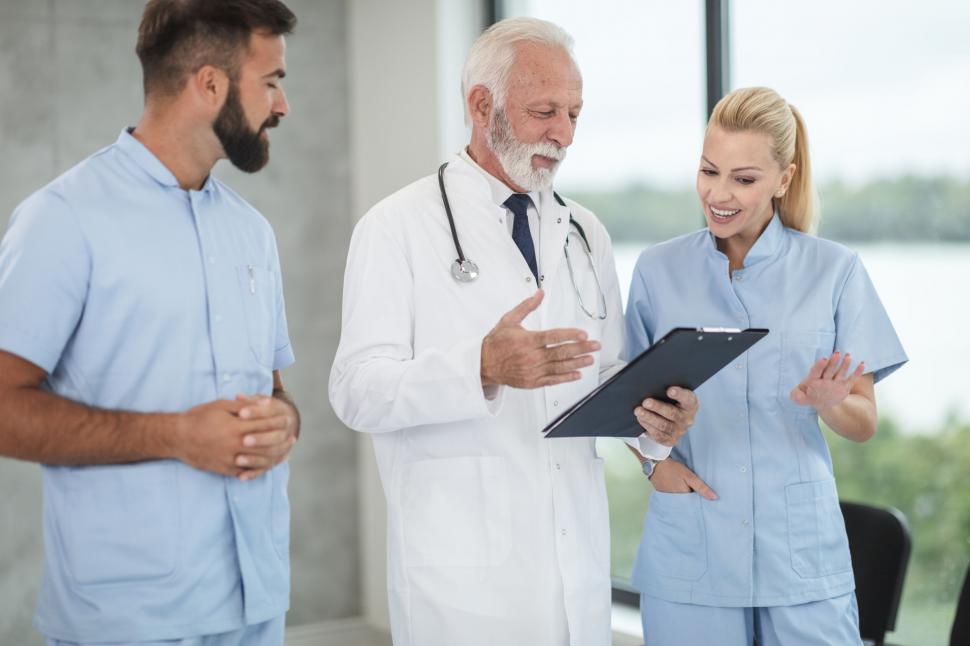 Free Image of Medical team discussing over clipboard 