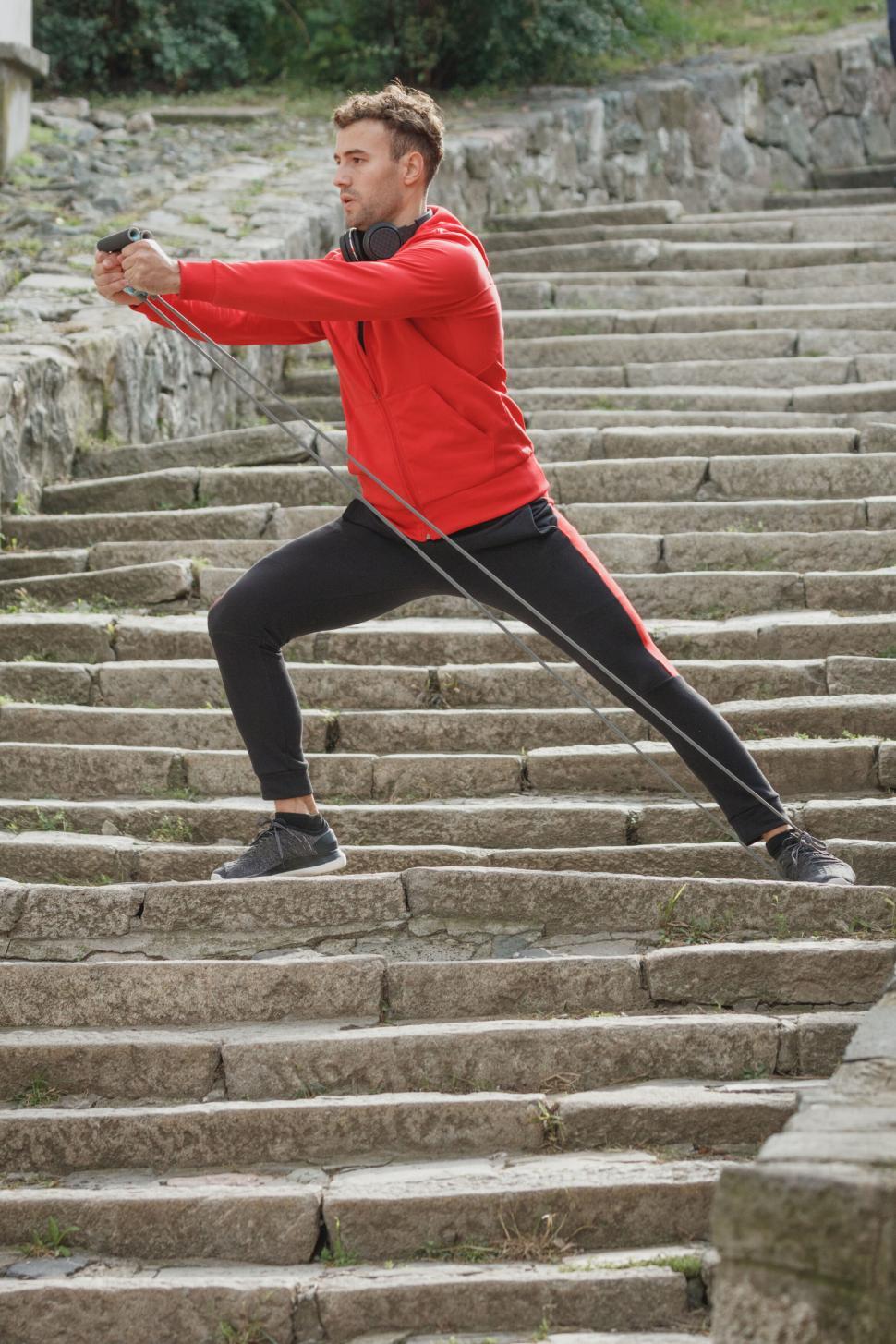 Free Image of Man doing lunges on stone stairs 