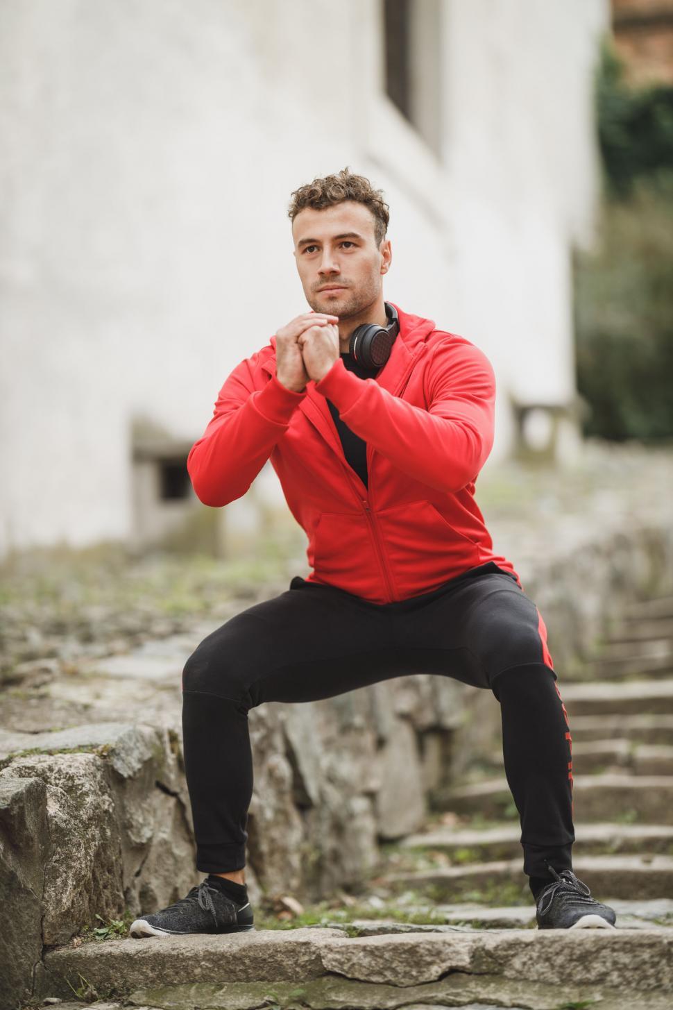 Free Image of Focused man doing squats on steps 