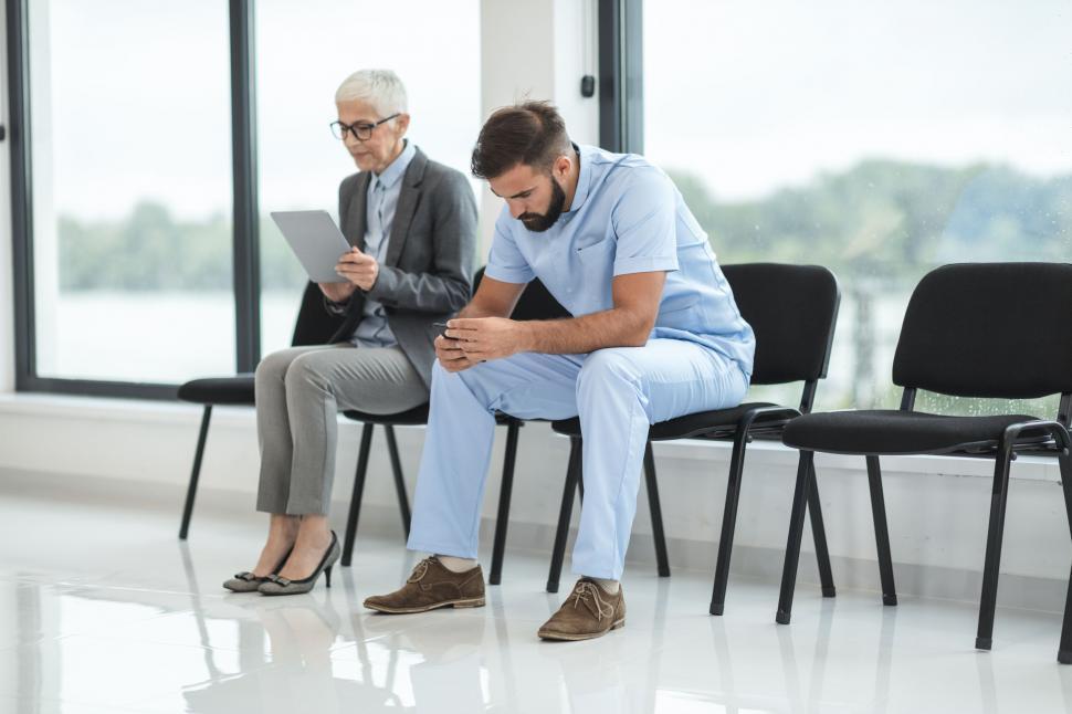 Free Image of Nurse looking at phone in medical waiting area 