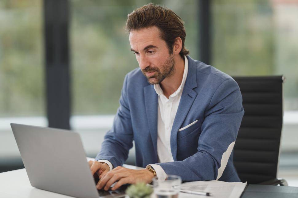 Free Image of Businessman focusing on laptop in modern office 