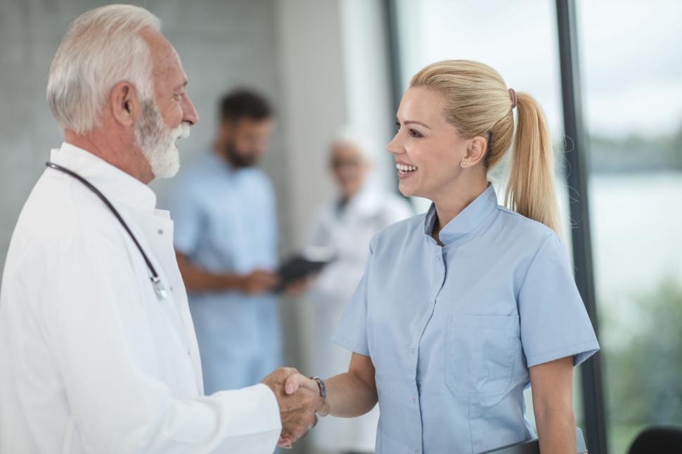 Free Image of Doctor and nurse shaking hands in hospital setting 