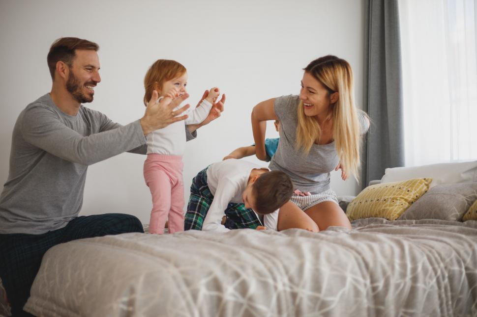 Free Image of Family laughter and playtime on bed 