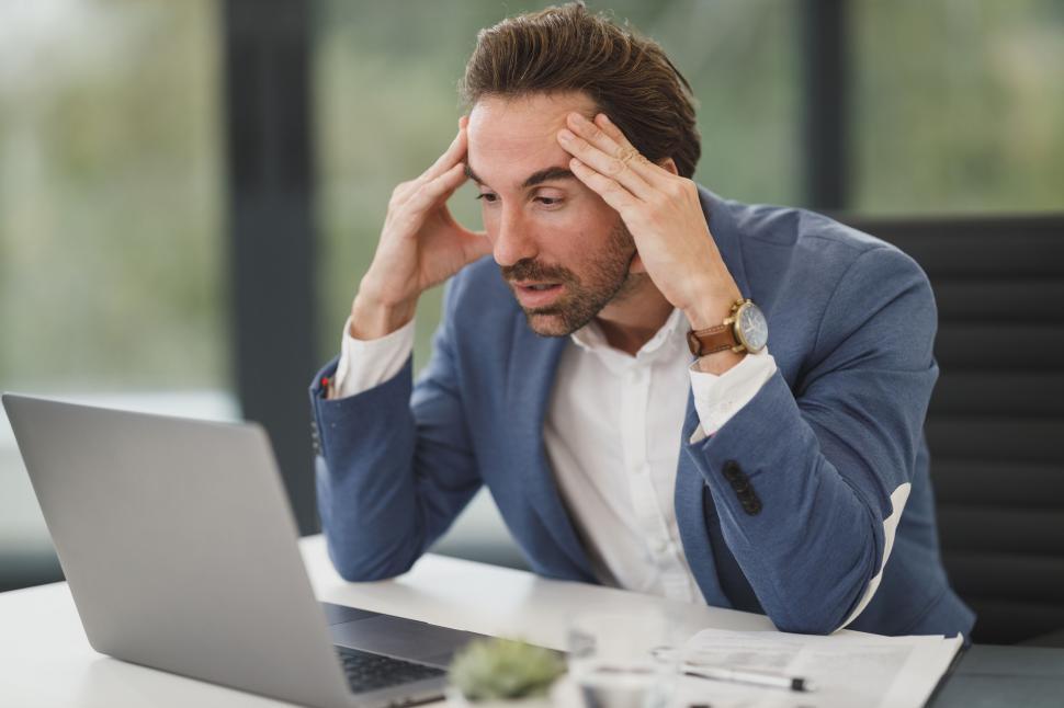 Free Image of Stressed man working on a laptop in office 
