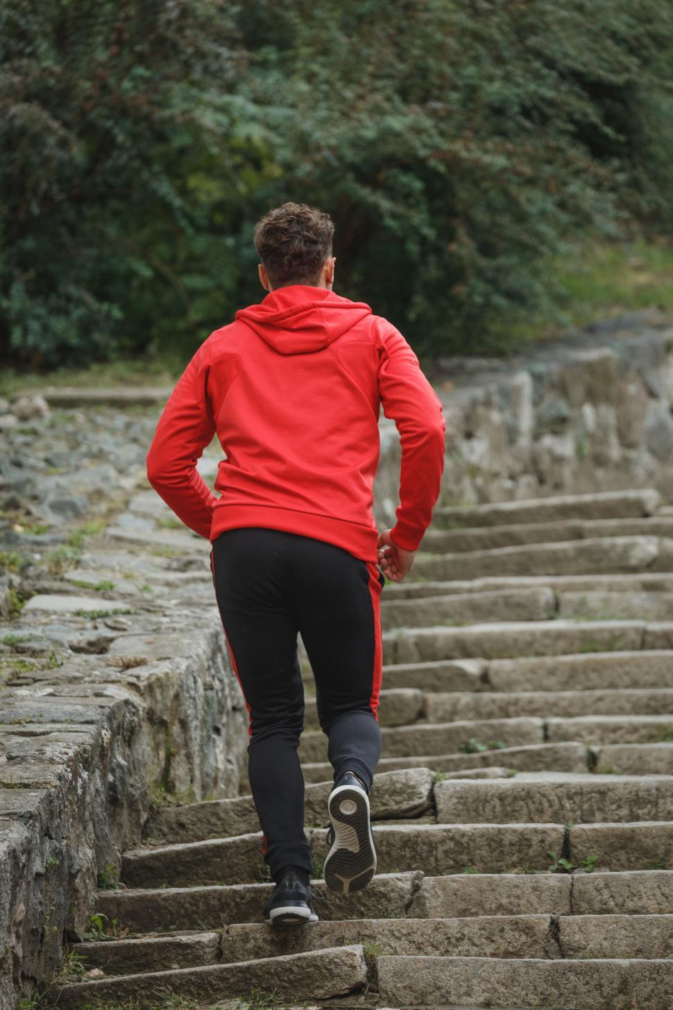 Free Image of Man jogging up ancient stone steps 