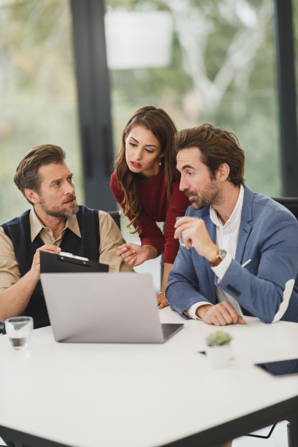 Free Image of Colleagues discussing over laptop in office 