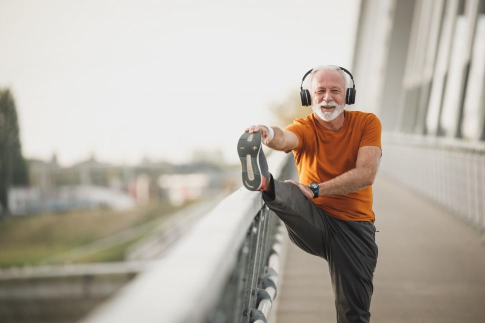 Free Image of Elderly man stretching with headphones on 