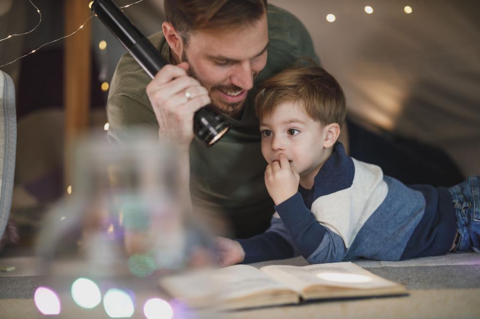 Free Image of Father and son reading with a flashlight 